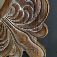 Wooden carvings with intricate designs on a dark background