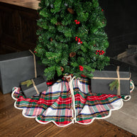 Plaid Christmas tree skirt with presents underneath a decorated tree.