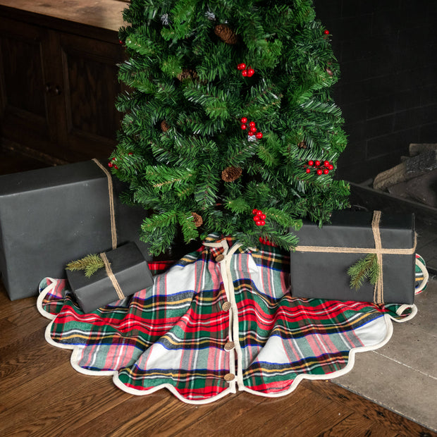 Plaid Christmas tree skirt with presents underneath a decorated tree.