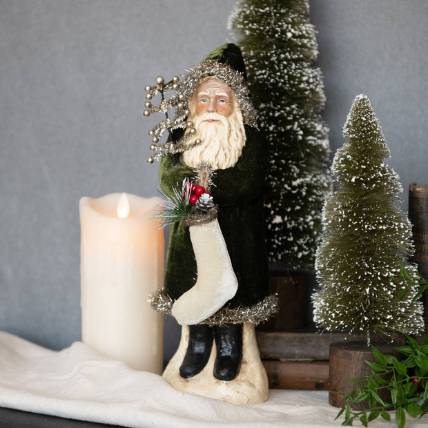 Decorative figure of a winter scene with a candle and small trees on a gray background