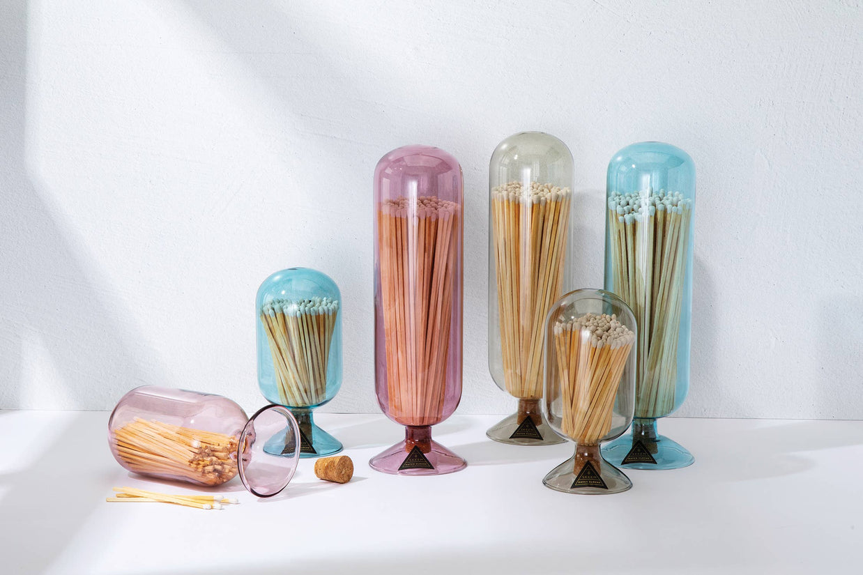 Set of colorful glass containers with toothpicks on a white background