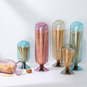 Set of colorful glass containers with toothpicks on a white background