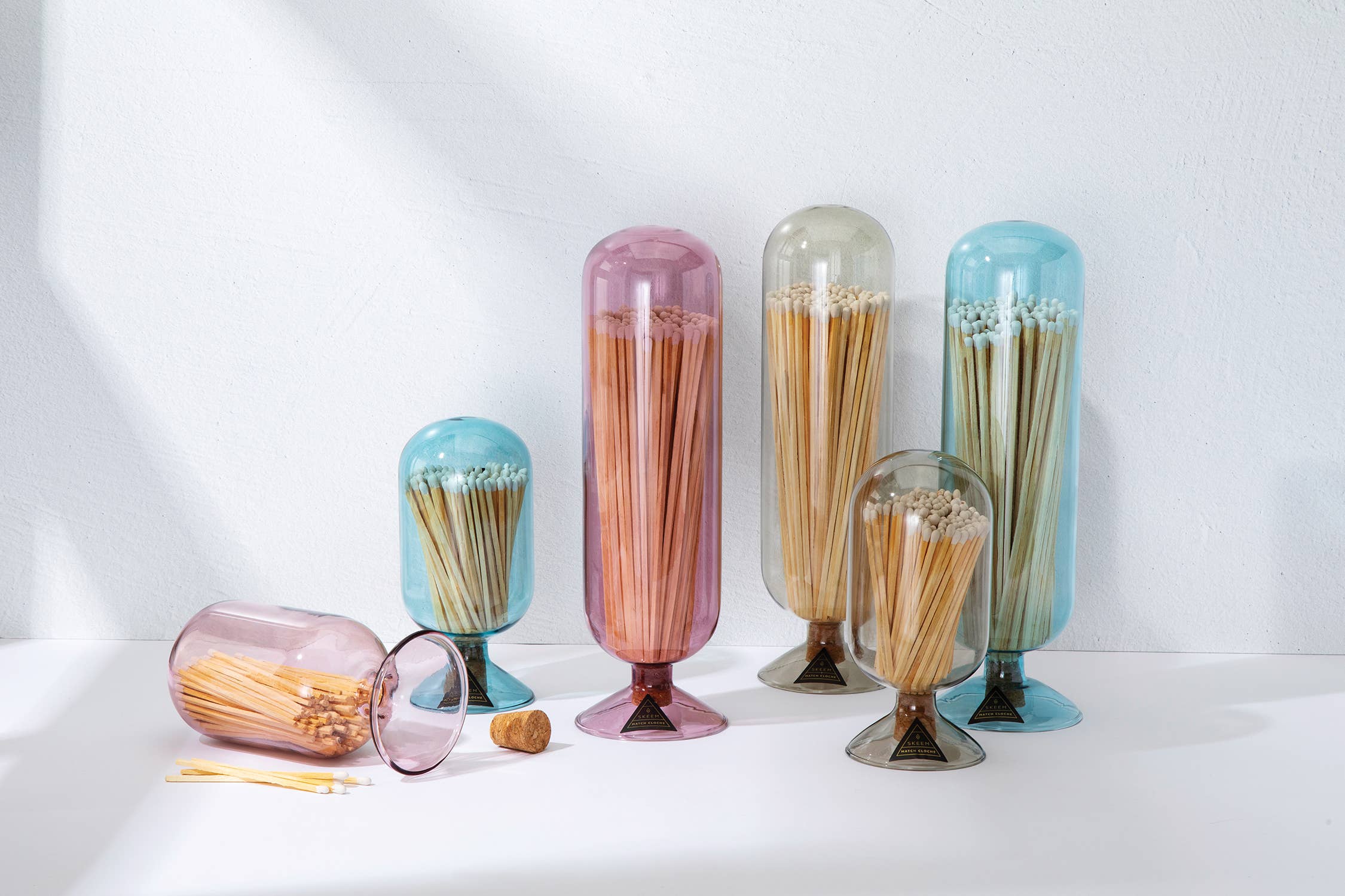 Set of colorful glass containers with toothpicks on a white background
