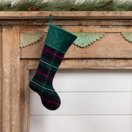 Green Tartan stocking hanging from faux wooden mantle. 