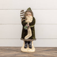 Decorative figure of a bearded man in a green coat holding a tree against a white wooden background.