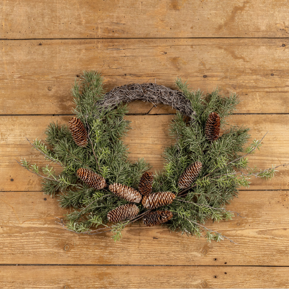 Wreath with pine cones on a wooden surface