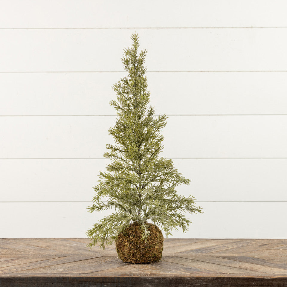 Small artificial Christmas tree on a wooden surface with a white wooden background