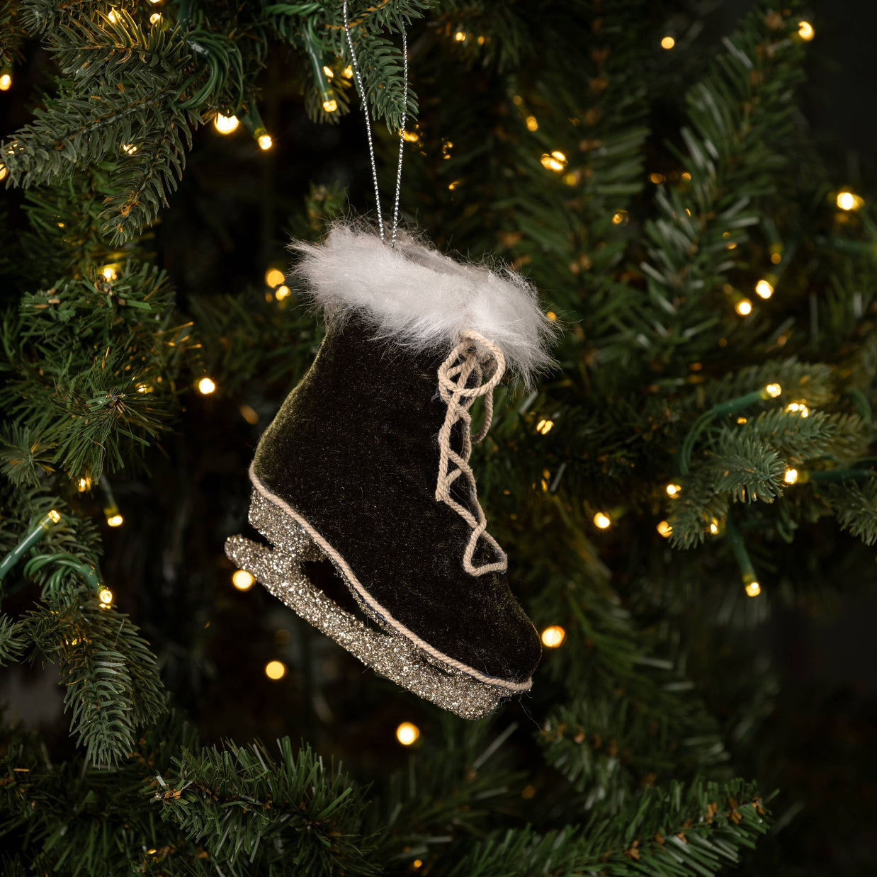 Black ice skate ornament with white fur on a Christmas tree.