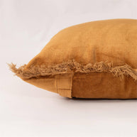 Brown pillow with frayed edge on a white background