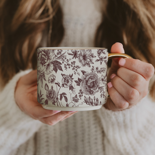 Person holding a mug with floral pattern