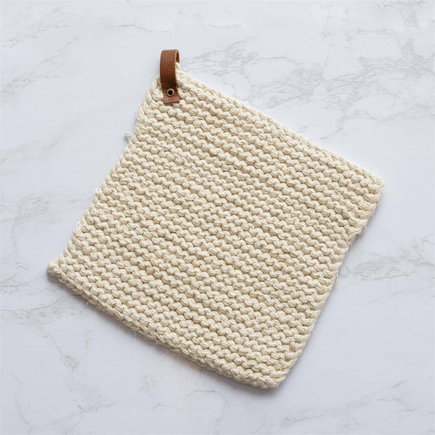 Beige woven potholder with leather strap on a light marble background