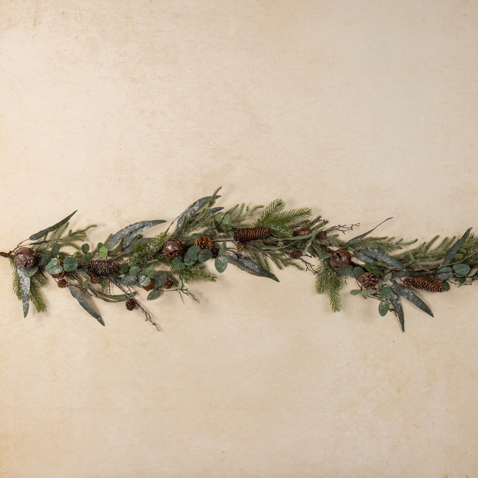 Greenery garland with pinecones on a beige background