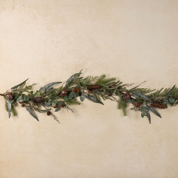 Greenery garland with pinecones on a beige background