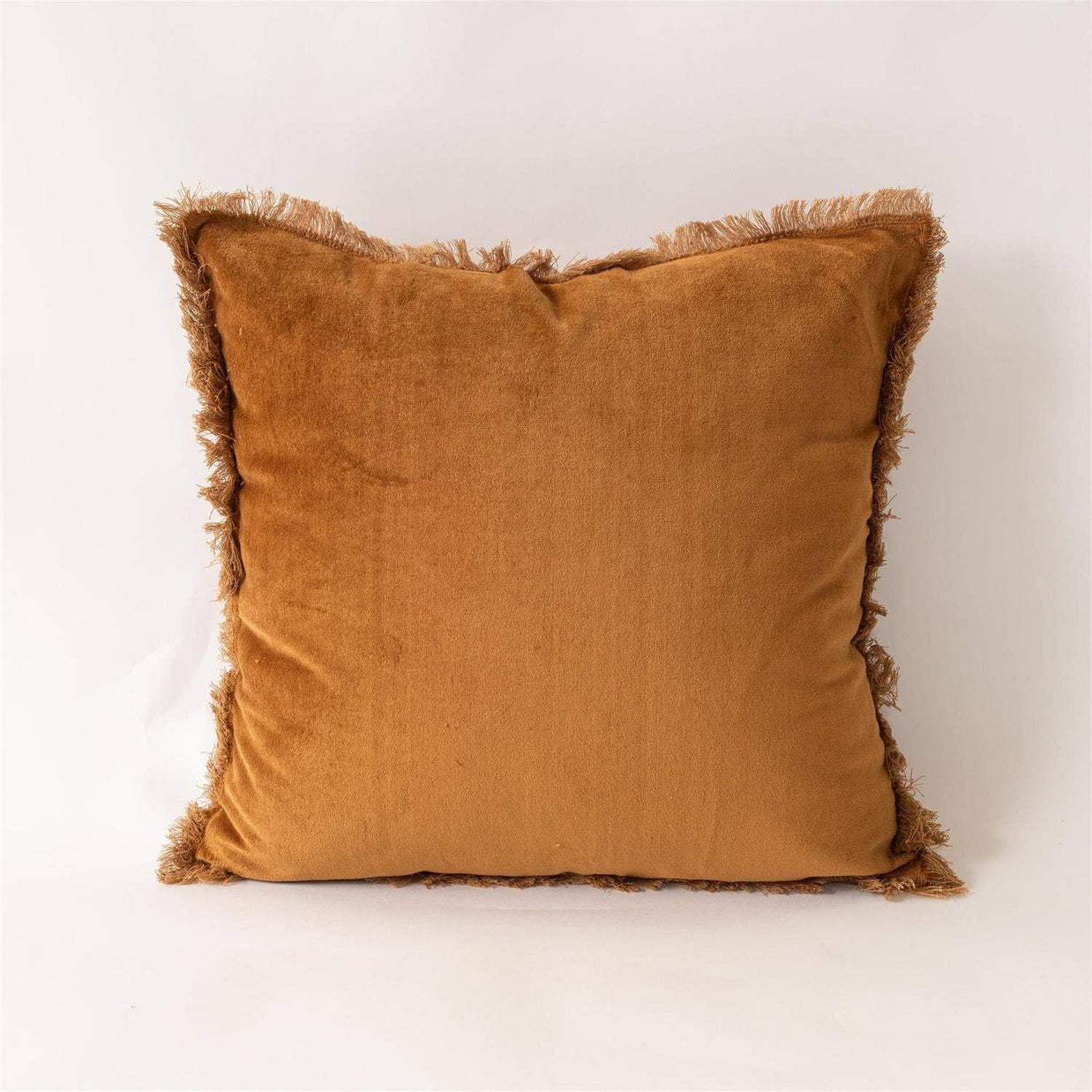 Brown velvet pillow with frayed edges on a white background