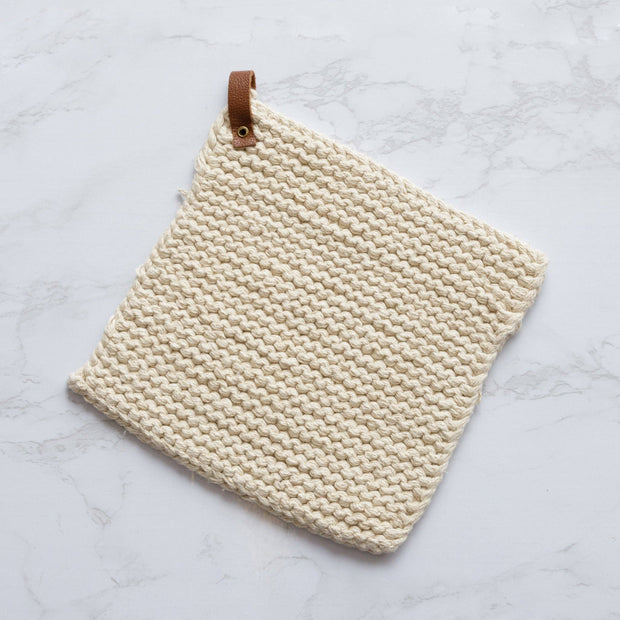 Beige woven potholder with leather strap on a light gray background