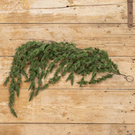 Green artificial garland on a wooden surface