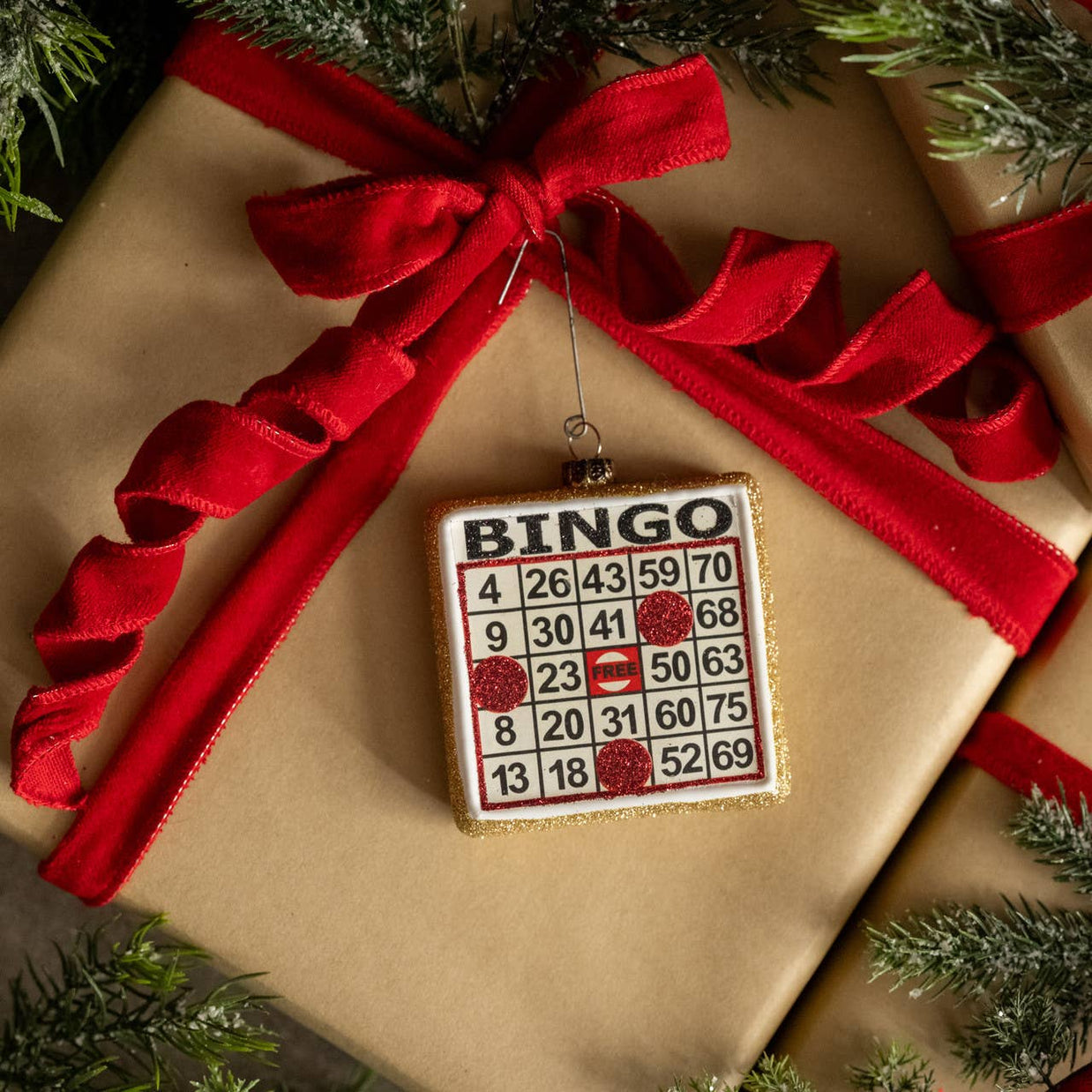 Bingo-themed ornament on a wrapped gift with a red ribbon