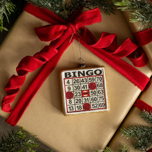 Bingo-themed ornament on a wrapped gift with a red ribbon