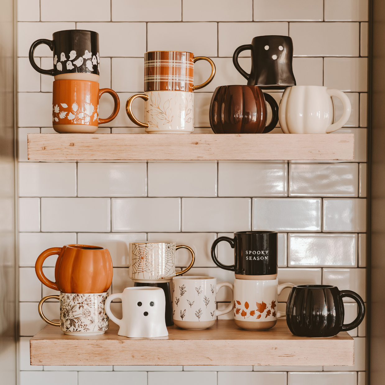Collection of various mugs on wooden shelves against a tiled wall.