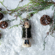 Decorative angel ornament on a snowy background with pinecones and branches