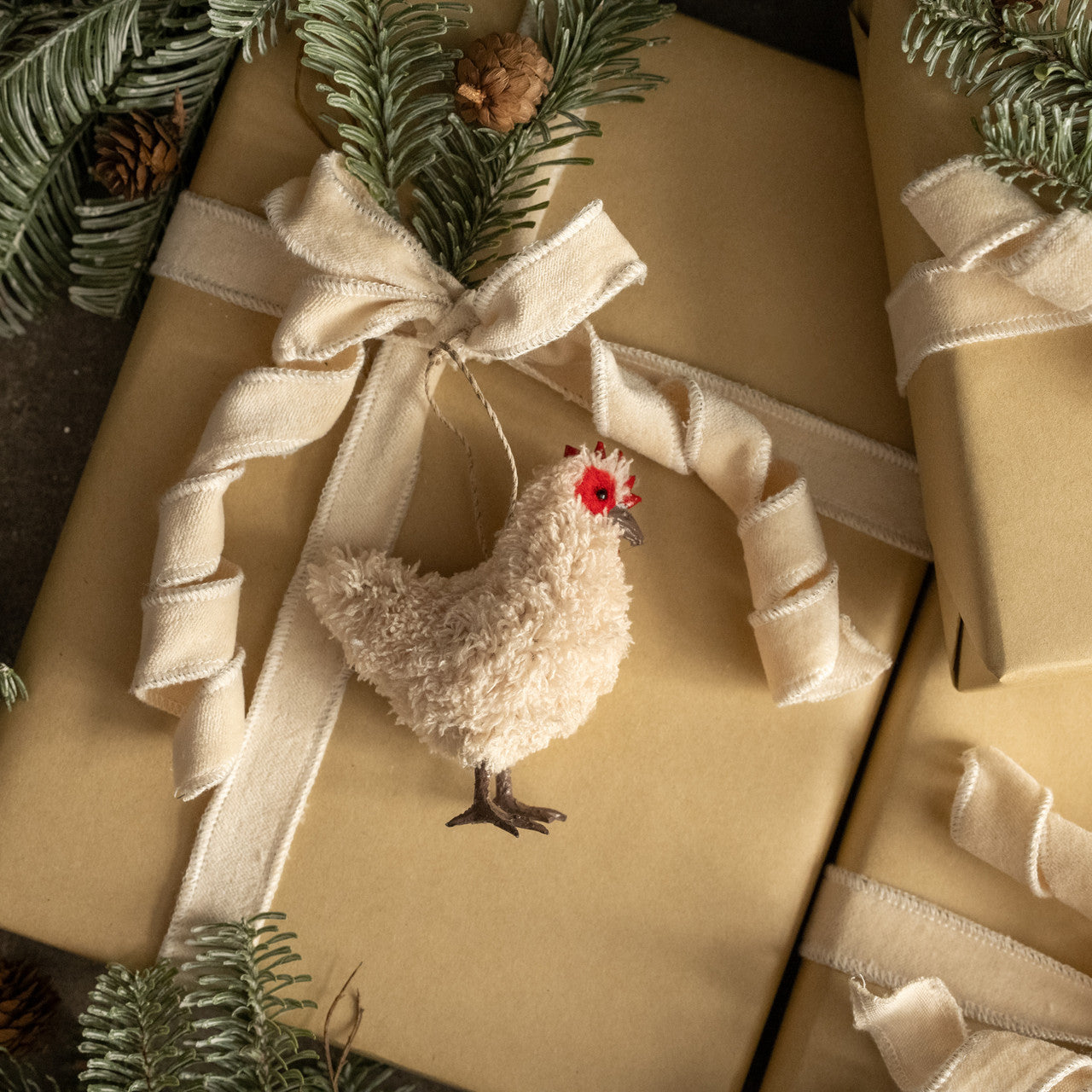 Gift wrapped in gold paper with a decorative chicken ornament and ribbon.