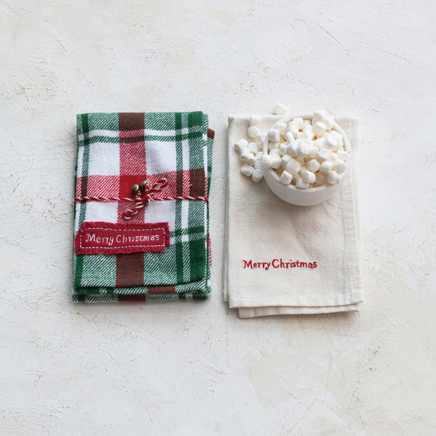 Two Christmas-themed napkins with 'Merry Christmas' text on a light surface.