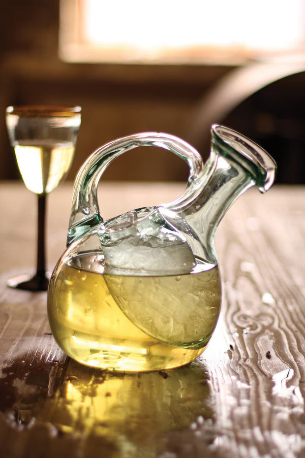 Tilted pitcher with ice pocket filled with white wine. 