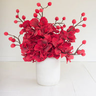 Bright red blooming flowers in a white pot.