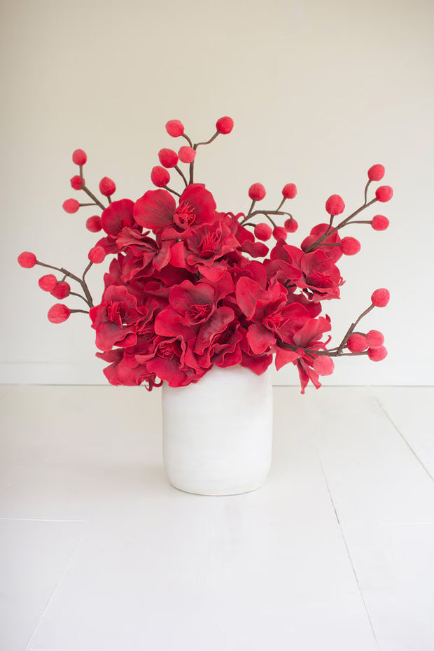 Bright red blooming flowers in a white pot.