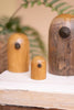 Three wooden ornaments on a white surface with a blurred natural background