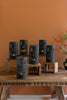 Set of blue jack-o'-lantern candle holders on a wooden table against an orange wall.