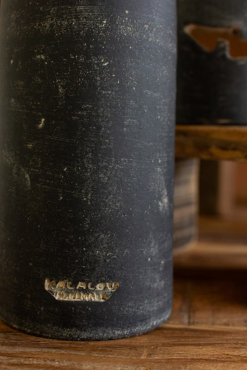 Black ceramic vase with 'Kilgour' branding on a wooden surface