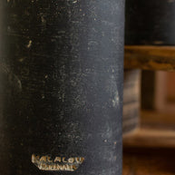 Black ceramic vase with 'Kilgour' branding on a wooden surface