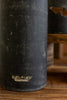 Black ceramic vase with 'Kilgour' branding on a wooden surface