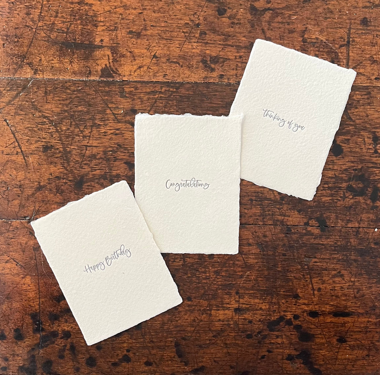 Three white cards with text on a wooden surface