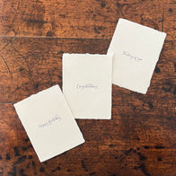 Three white cards with text on a wooden surface