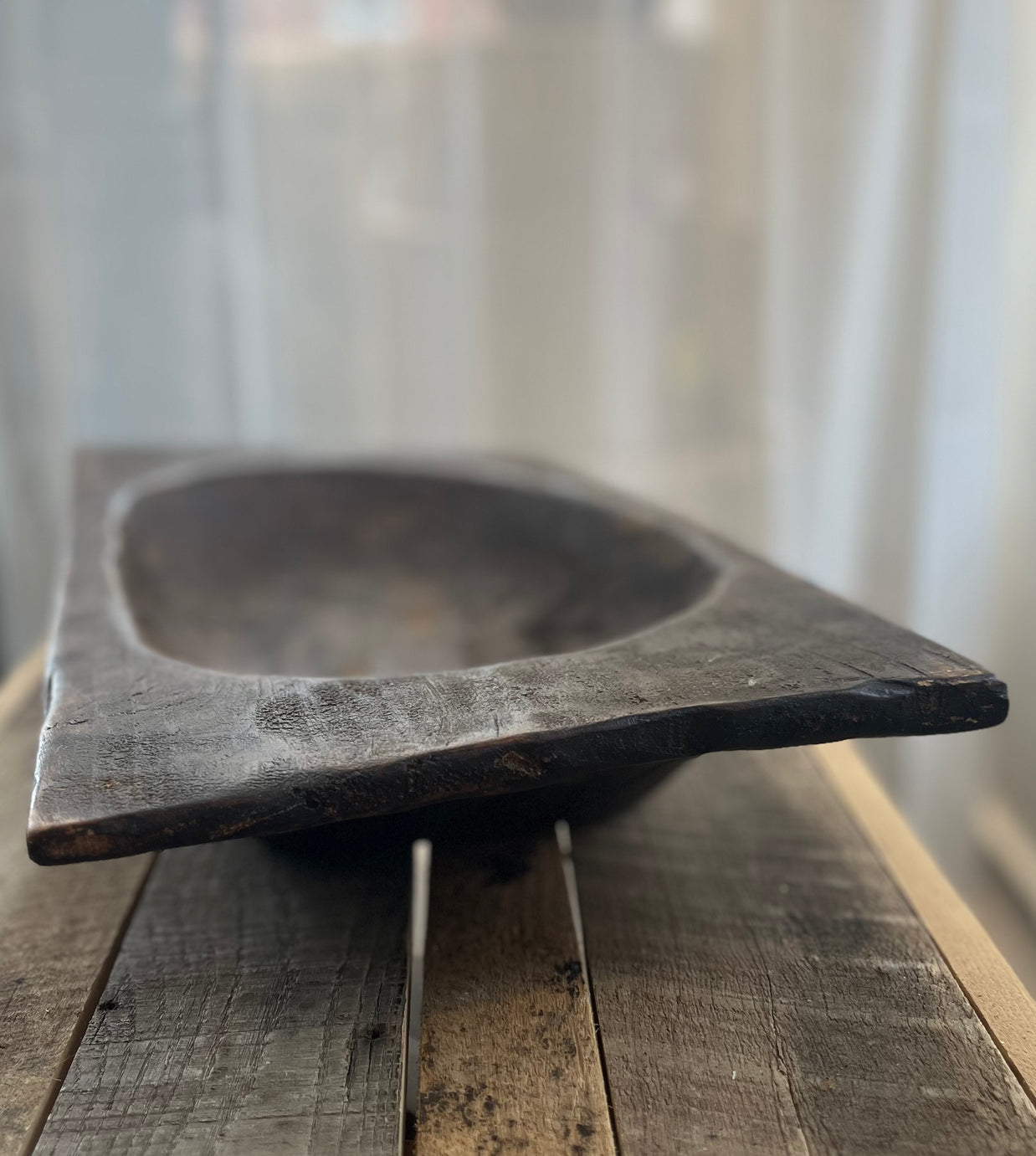 Wooden bowl on a wooden surface with a blurred background