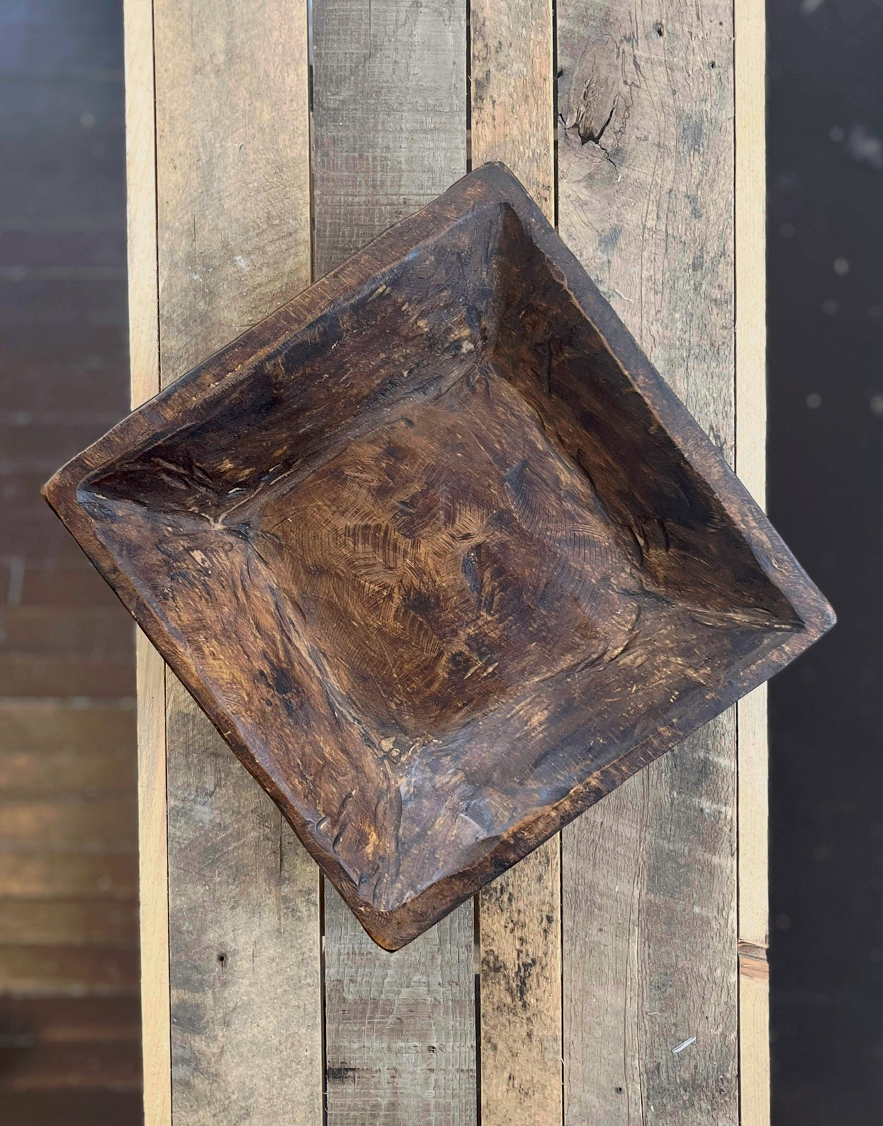 Wooden square tray on a wooden surface with a blurred background