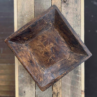 Wooden square tray on a wooden surface with a blurred background