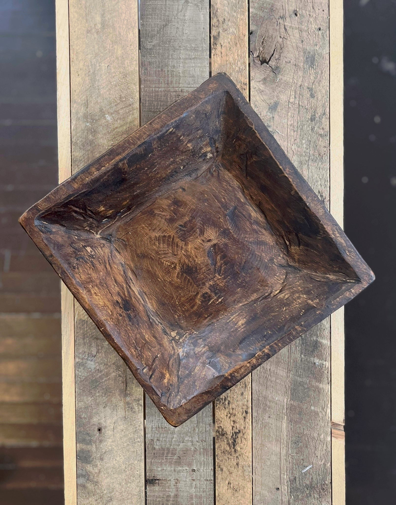 Wooden square tray on a wooden surface with a blurred background