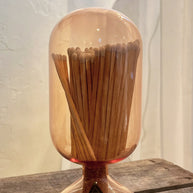 Wooden toothpick holder with a clear dome on a wooden surface