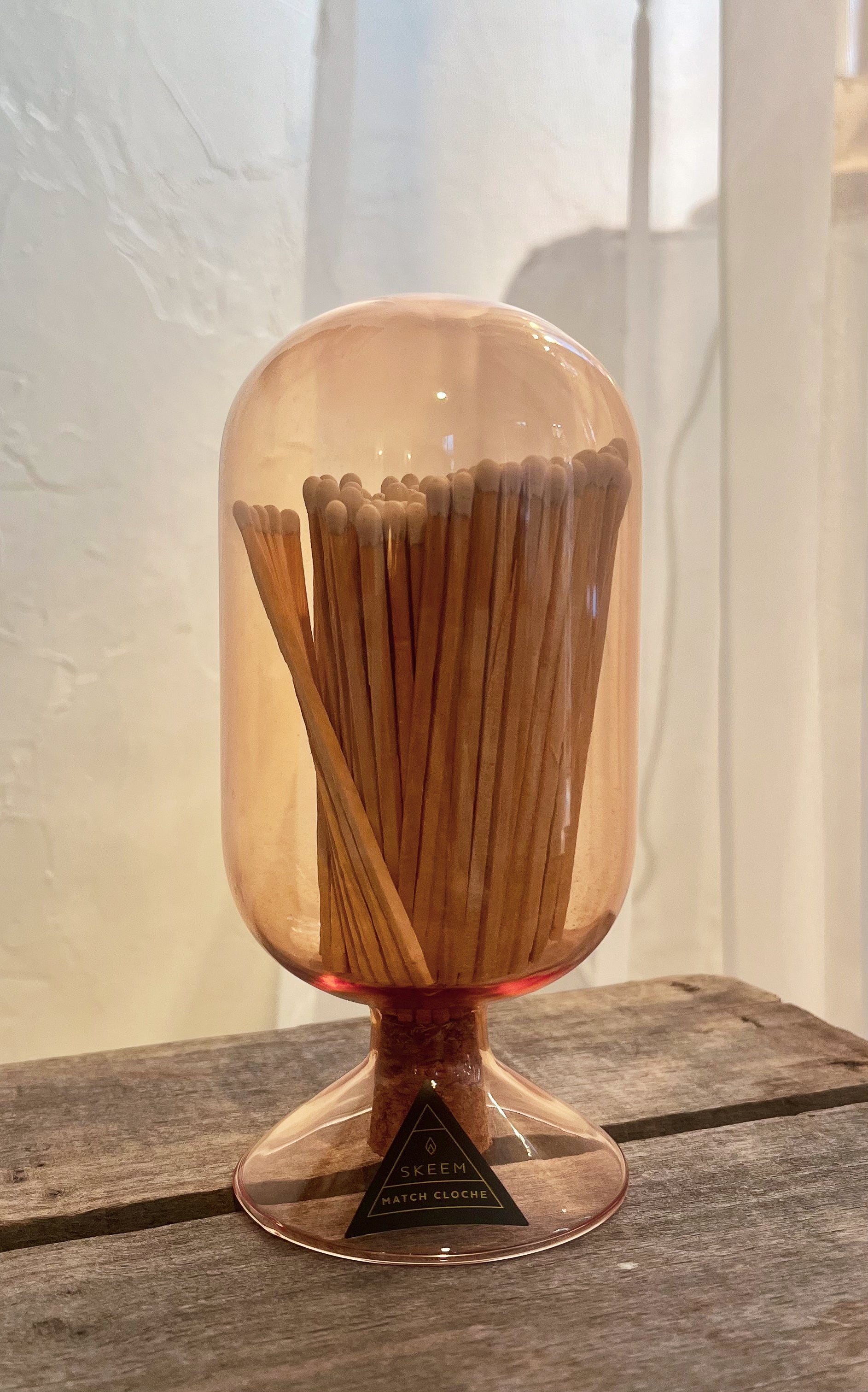 Wooden toothpick holder with a clear dome on a wooden surface