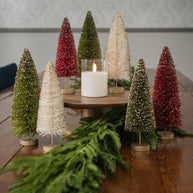 Decorative Christmas trees with a candle on a wooden table