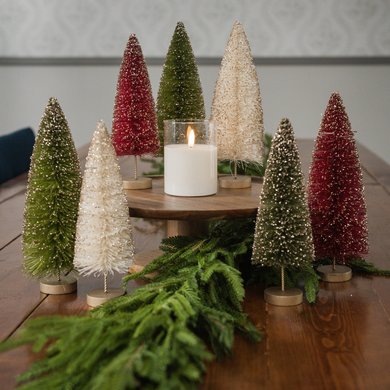 Decorative Christmas trees with a candle on a wooden table