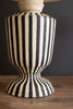 Striped lamp base with a dark background
