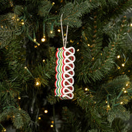 Decorative candy cane ornament on a Christmas tree with lights.
