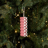 Red and white spiral Christmas ornament on a tree with lights