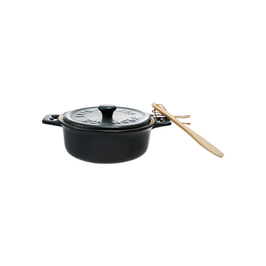 Black enameled cast iron cookware set with wooden spoon on a white background