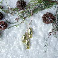 Decorative gold fish ornaments on a snowy background with pine branches and cones.
