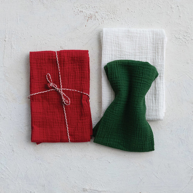 Red and green fabric items on a textured white surface